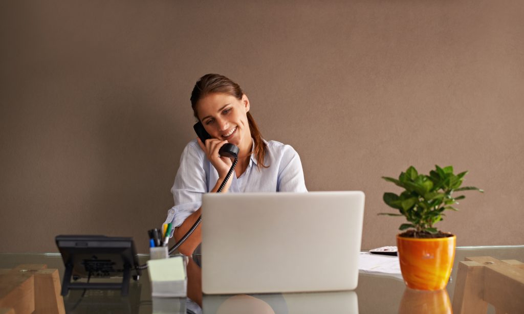 Getting in touch with a client. An attractive young woman working from her home office.